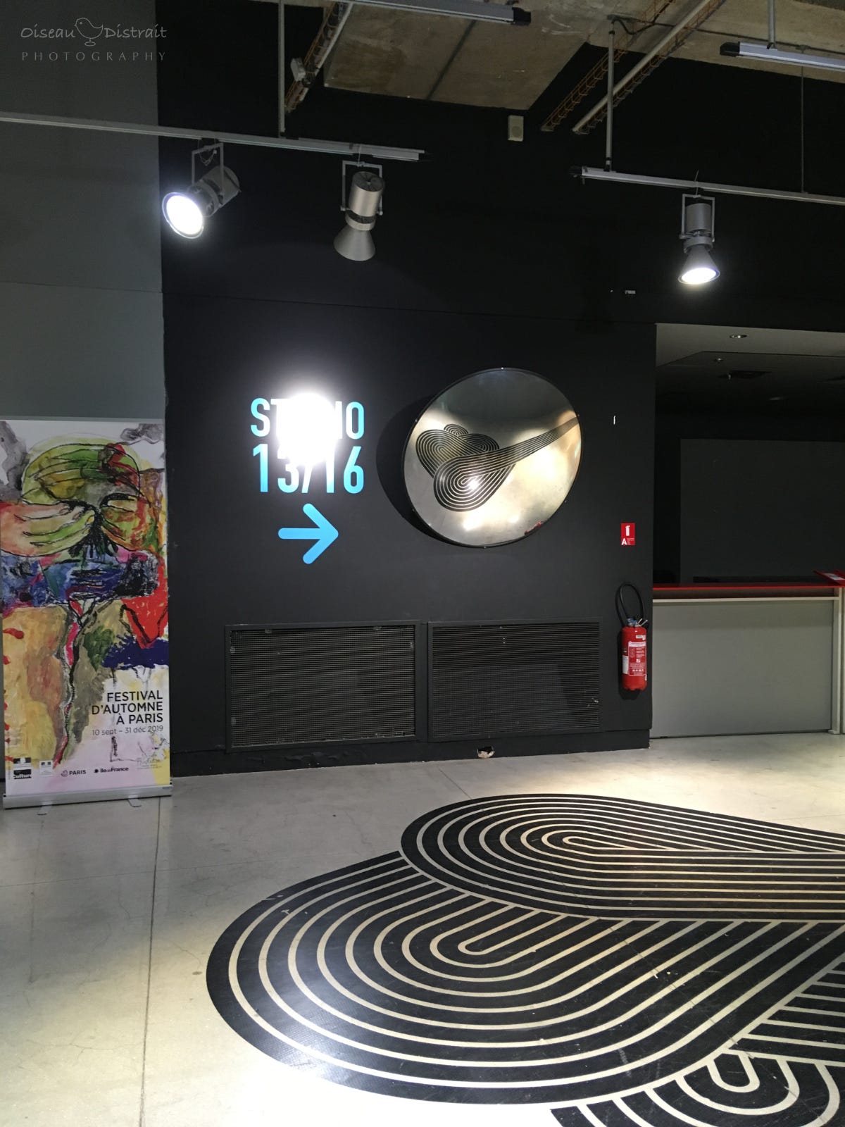 A floor graphic in black & white inside the museum. A wall art of studio 13/16 with a mirror reflected the graphic on the floor. A floor graphic in black & white inside the museum. A wall art of studio 13/16 with a mirror reflected the graphic on the floor.