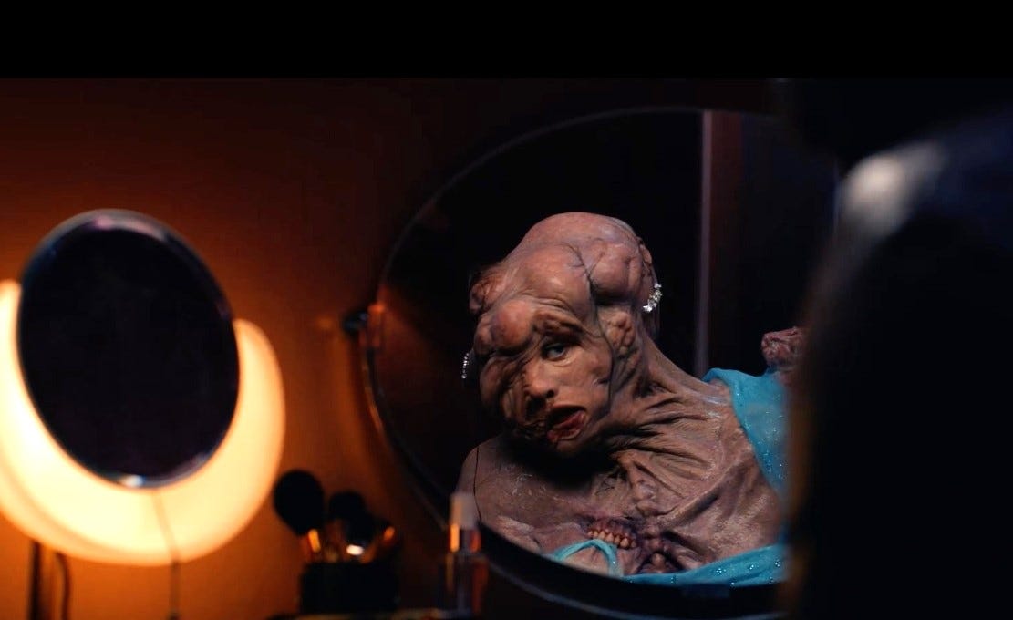 Cena de A Substância, em que a personagem de Demi Moore aparece monstruosa diante do espelho, com dois brincos de diamante presos na cabeça.