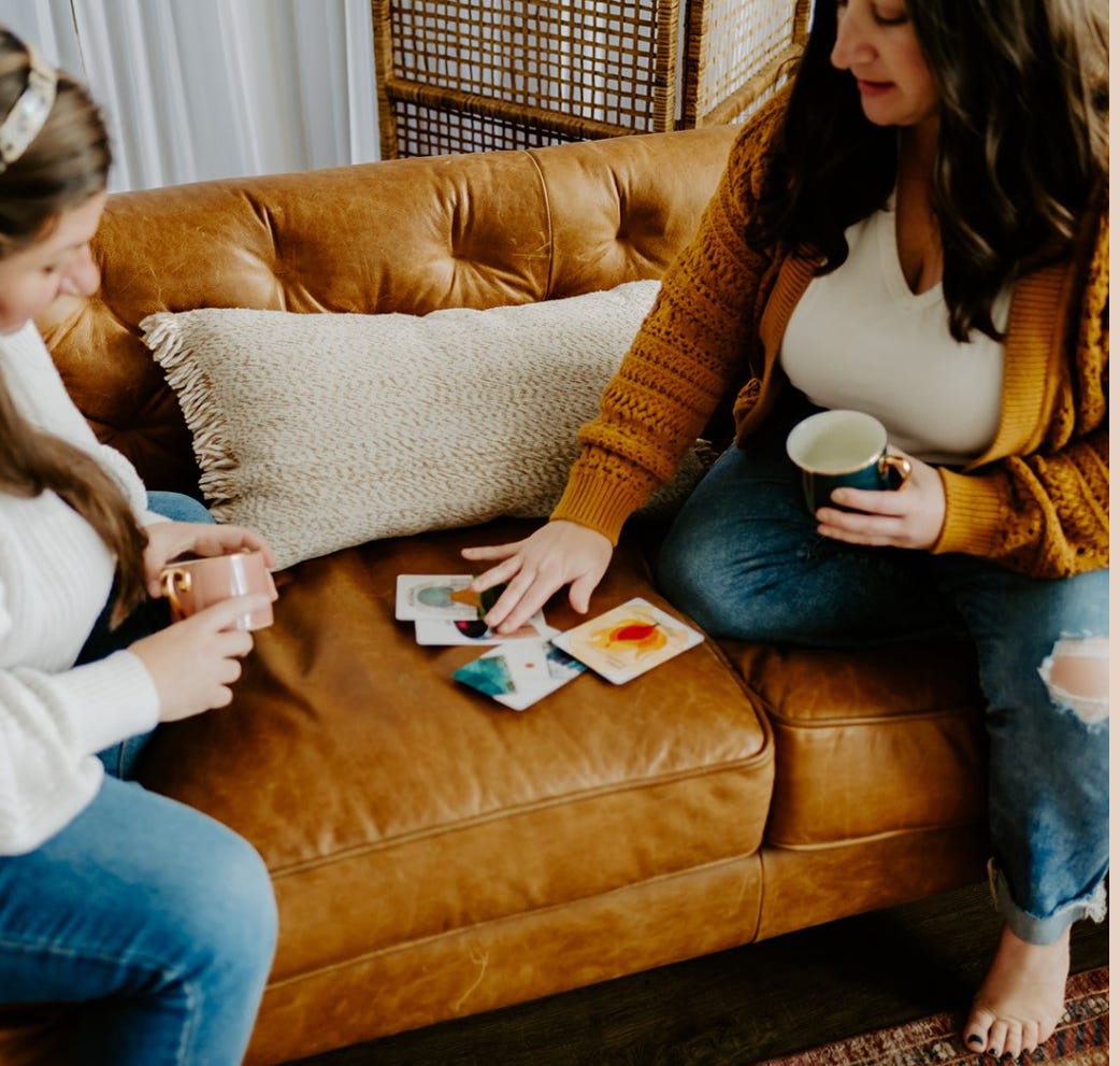 Katie pulling a card with a friend on a couch