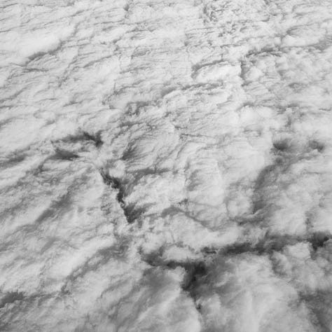 Three black and white abstraction photographs of clouds, water and lines on pavement.