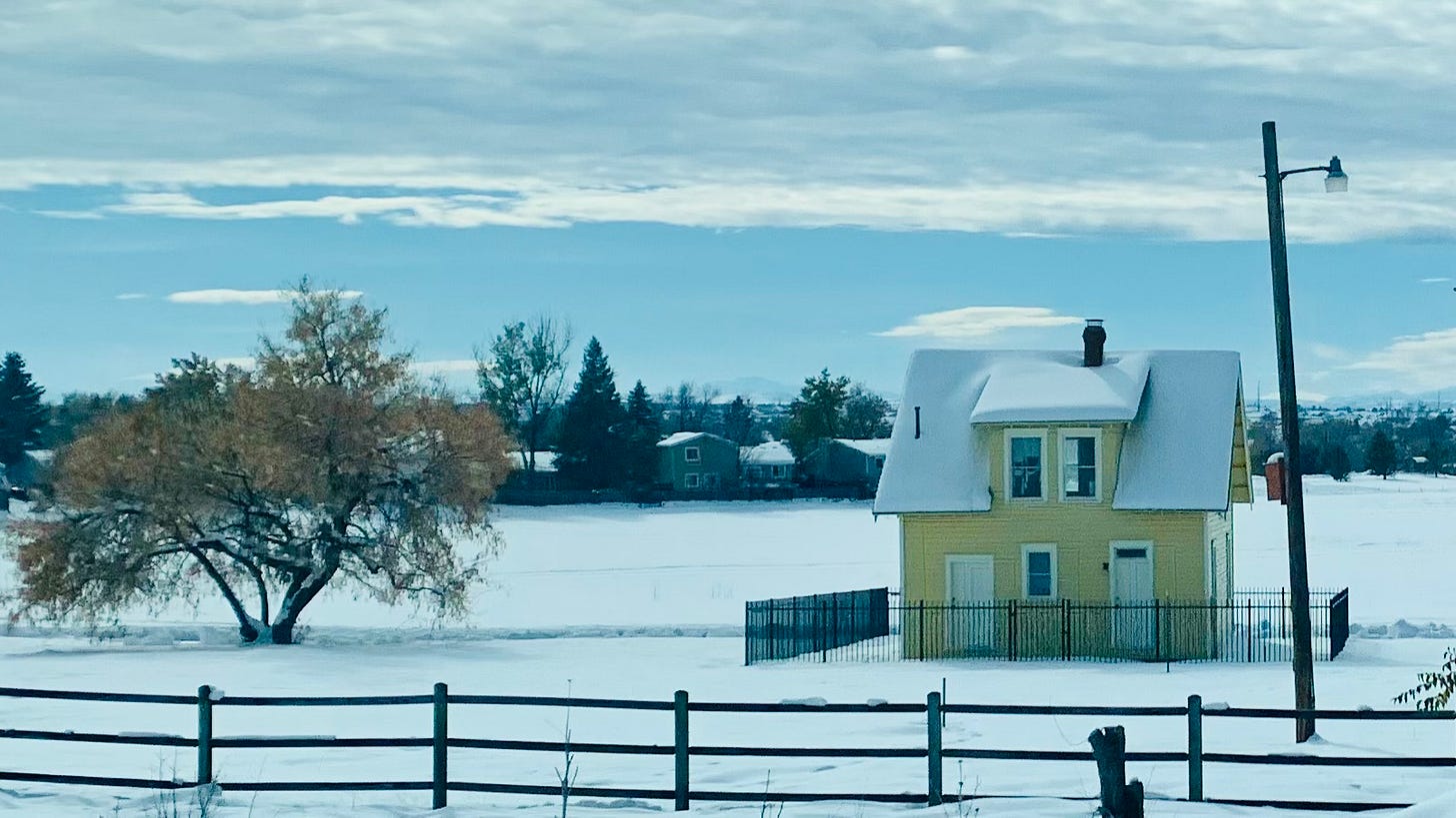 Image of a small house and fence in the snow.
