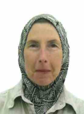 Slightly smiling woman in passport photo wearing black and white instant hijab. Slightly smiling woman in passport photo wearing black and white instant hijab.
