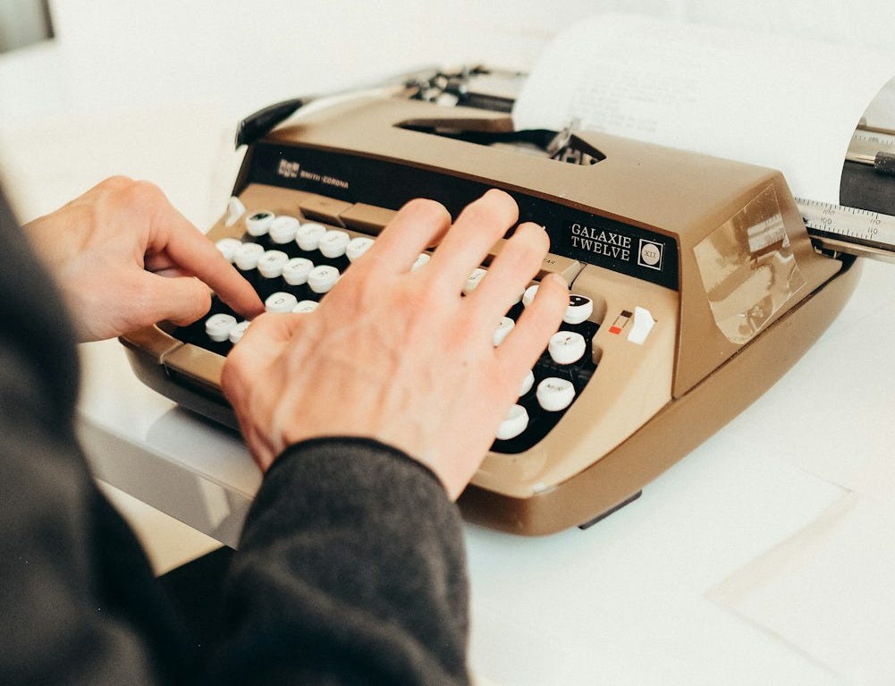 a person typing on an old fashioned typewriter a person typing on an old fashioned typewriter