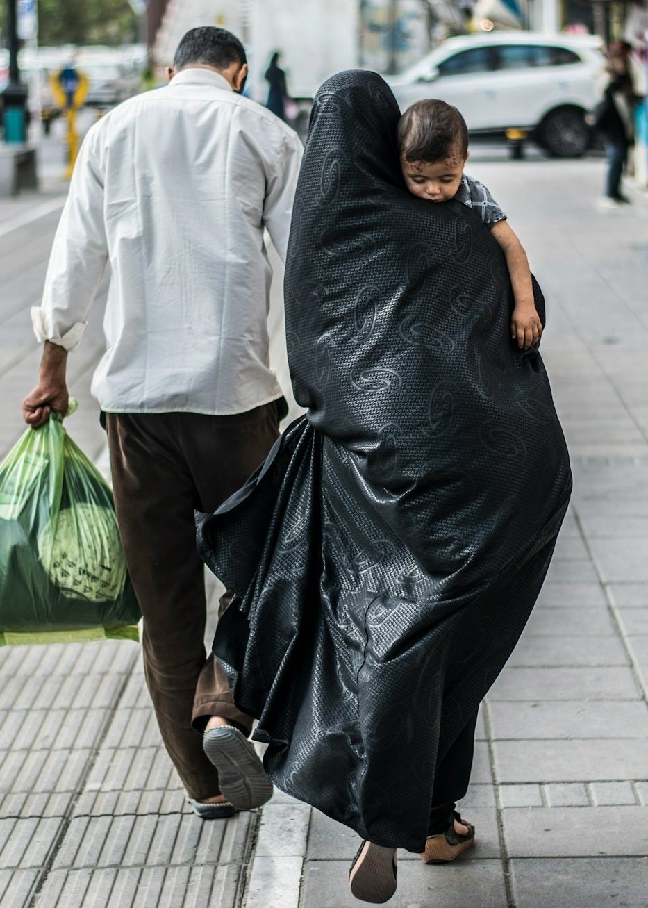 woman in black dress holding green plastic bag woman in black dress holding green plastic bag
