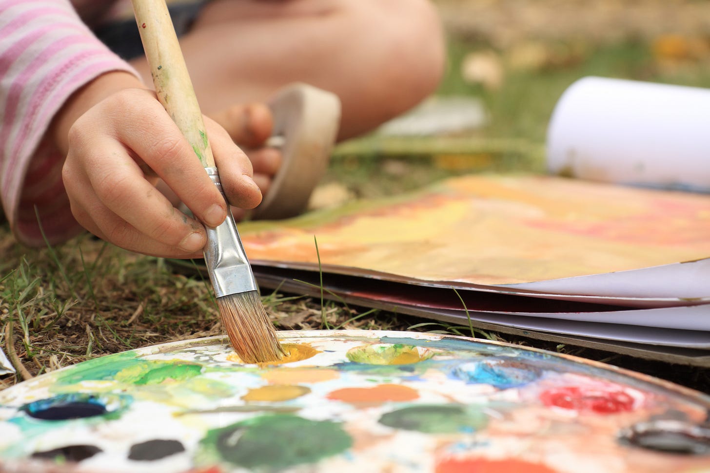 image of a child's hand, holding a paintbrush.