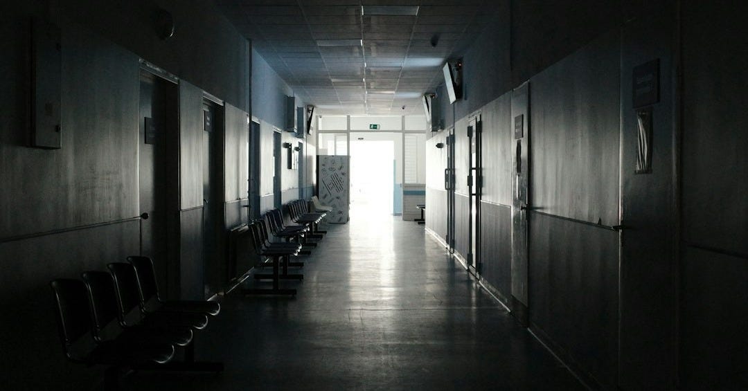 a dark hallway with benches and a television on the wall a dark hallway with benches and a television on the wall
