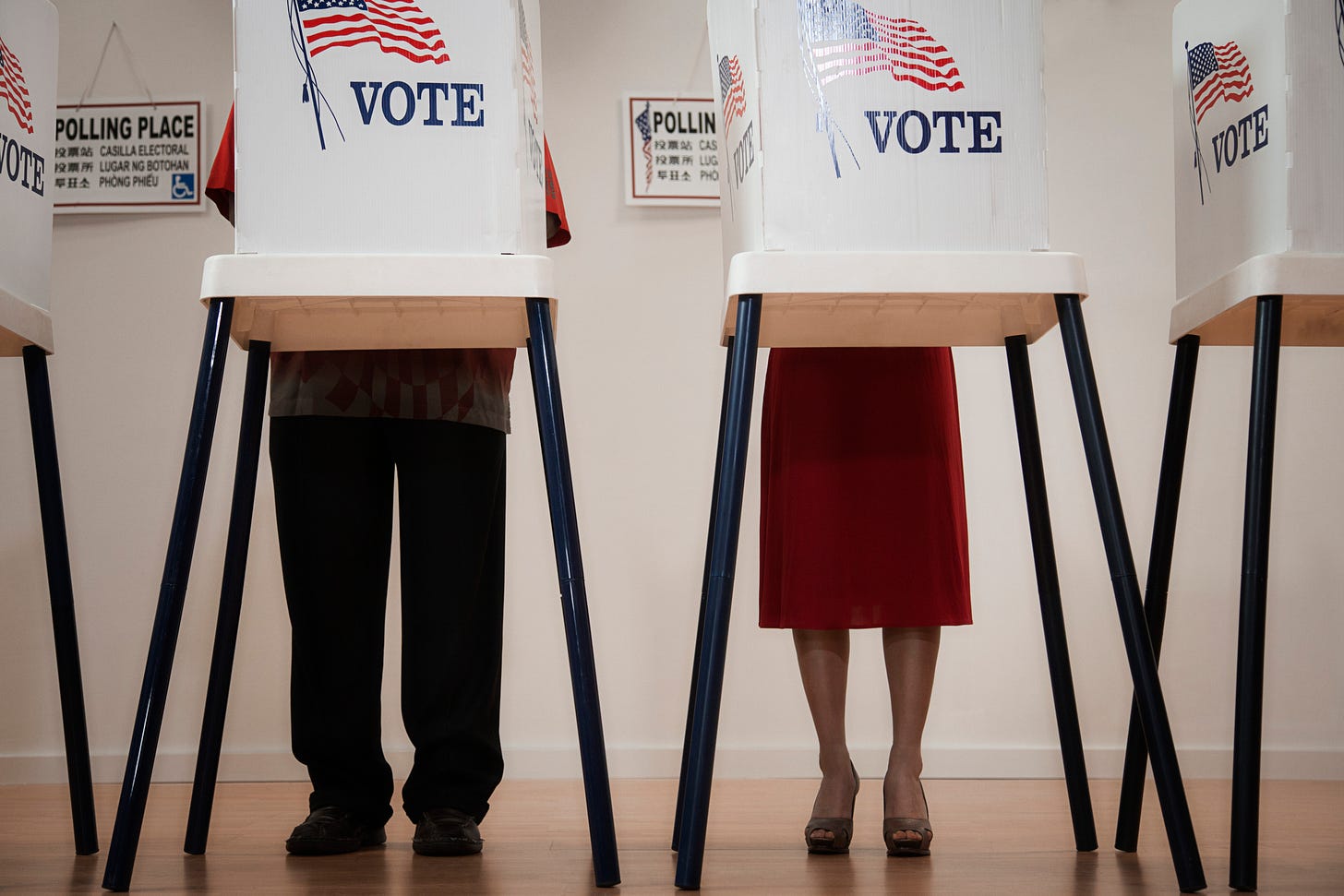 A man and woman vote. A man and woman vote.