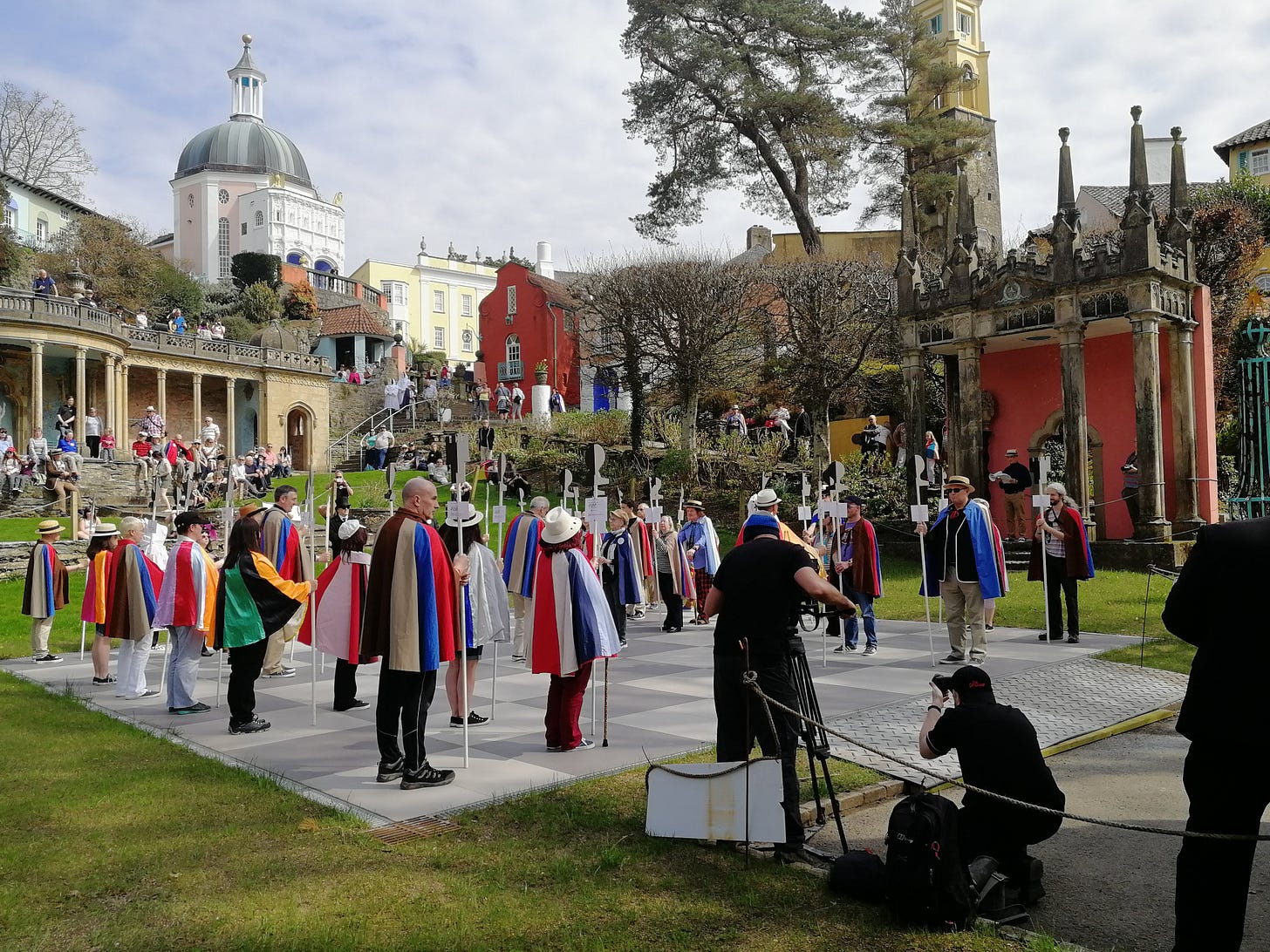 photograph of people wearing colourful capes on the chessboard in Portmeirion, while playing human chess being filmed