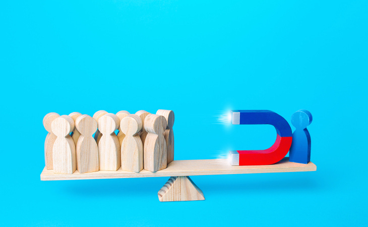 A person attracts people to his side with a magnet.