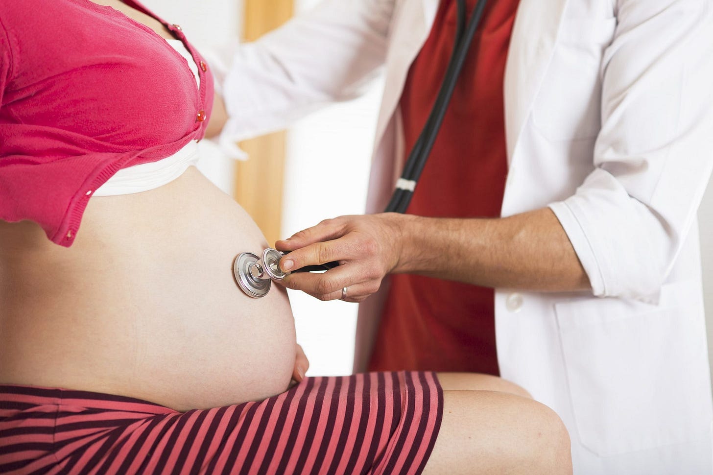 A pregnant woman being examined by their physican.