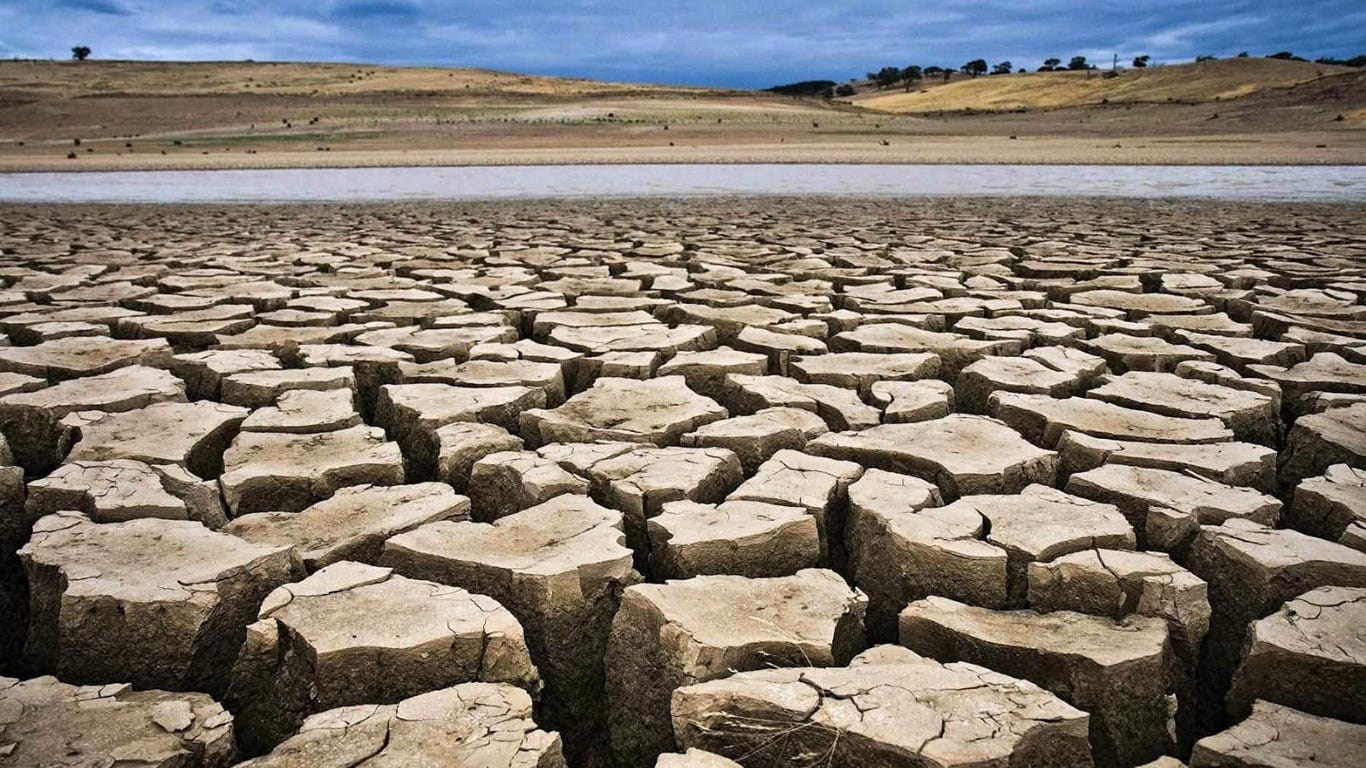 Closeup of deeply cracked, barren soil, parched hills in the background. Closeup of deeply cracked, barren soil, parched hills in the background.