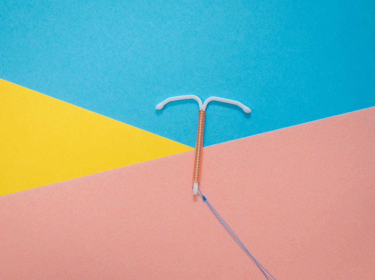 IUD on a brightly colored geometric background