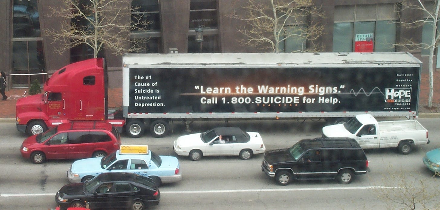 A tractor trailer with a 1.800.Suicide advertisement on it