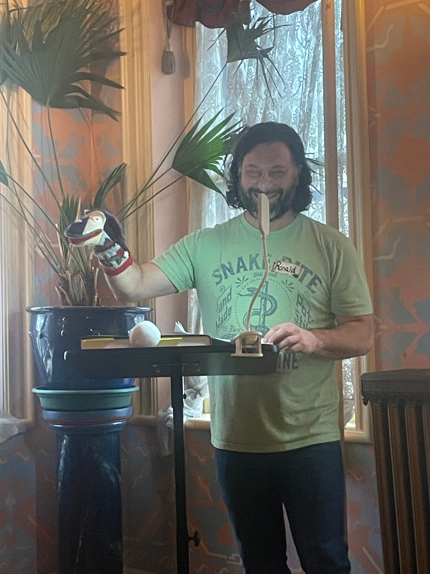 Author Ronald Malfi standing at a podium with a sock puppet on one hand.