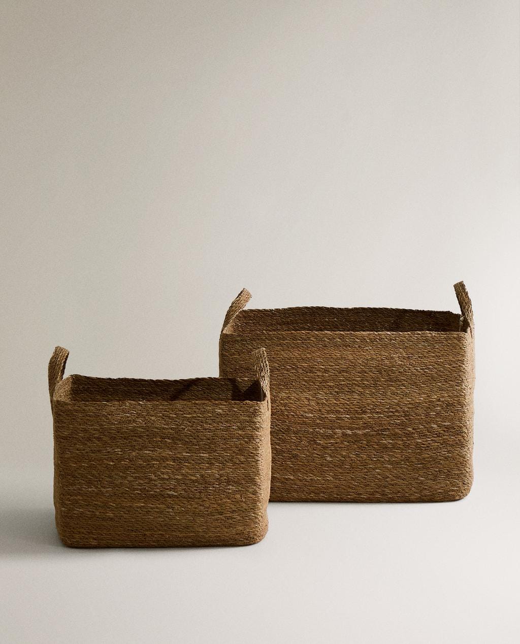Jute storage baskets in two sizes, with short handles.