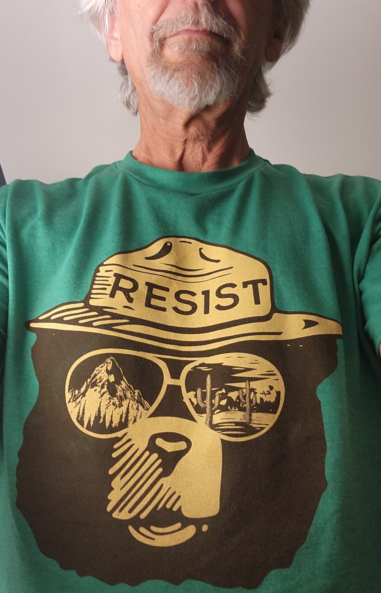 May be an image of 1 person, hat and text that says 'RESIST MI'