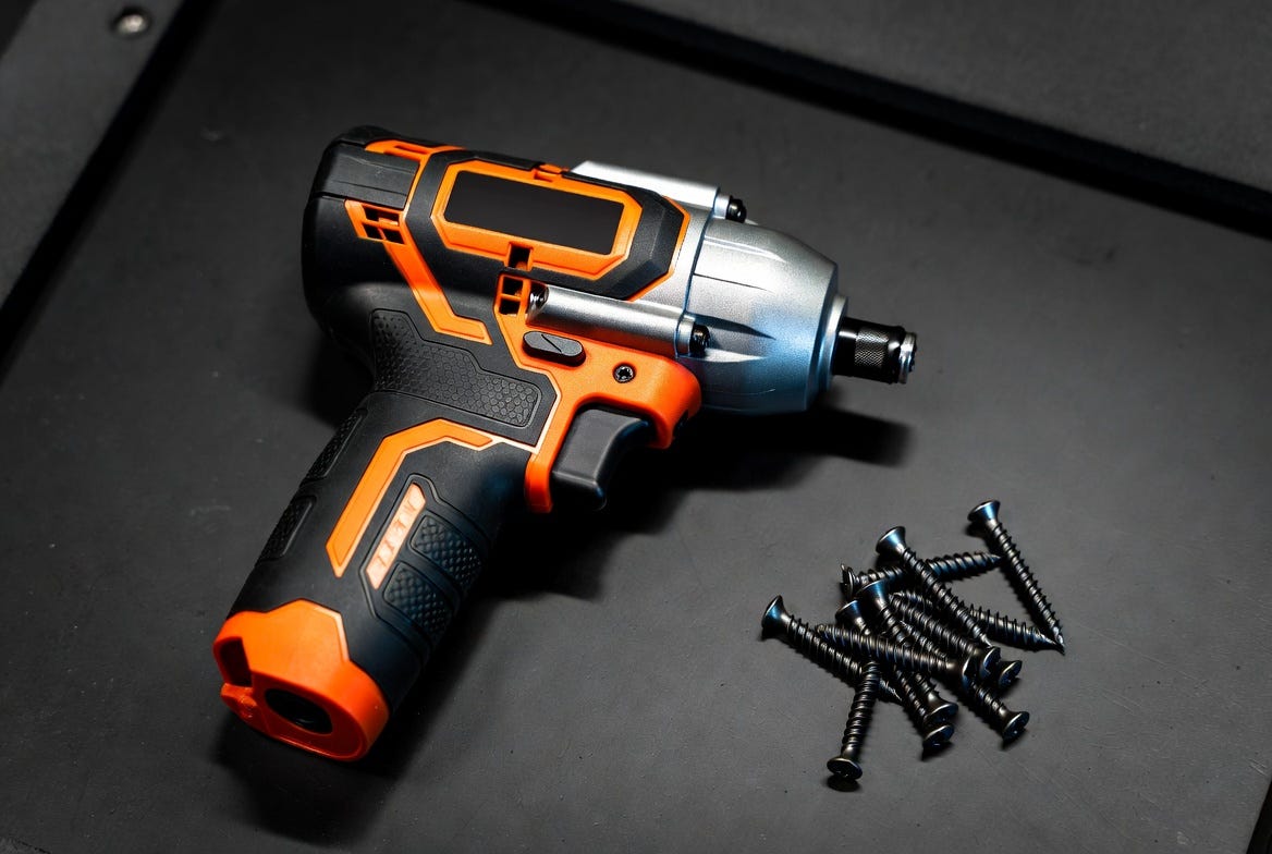 A photograph of an impact driver and screws on a workbench, emphasizing functionality in a working environment.