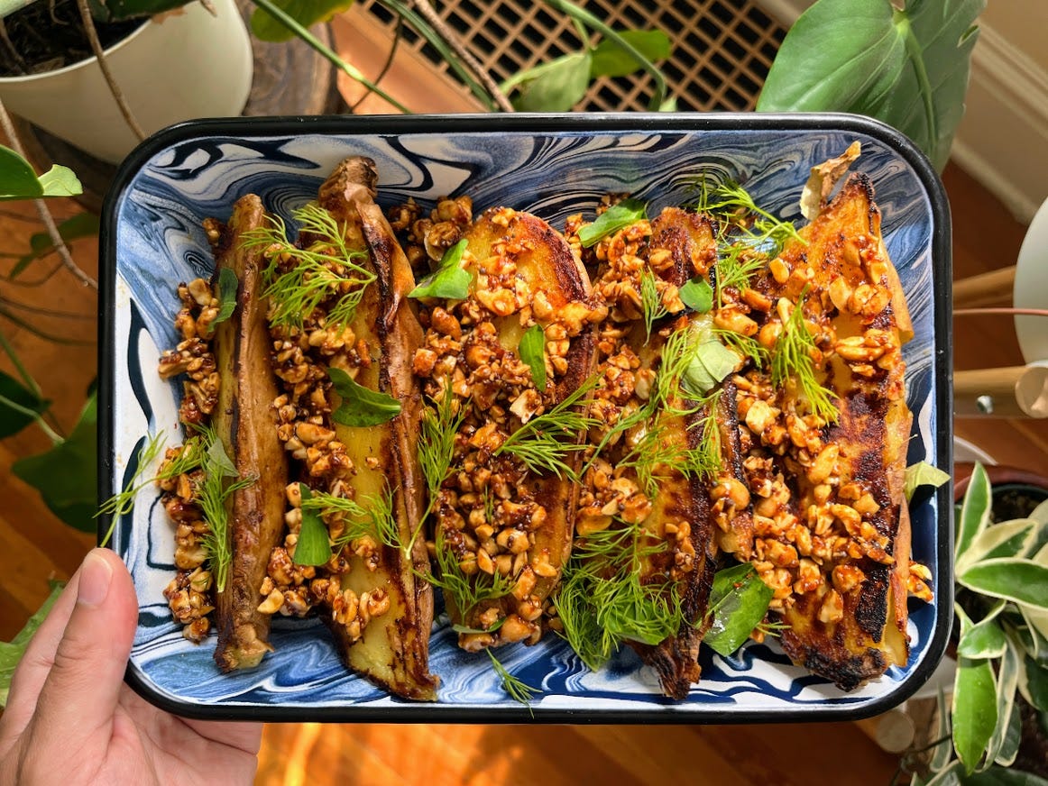 hand holding tray of baked sweet potatoes