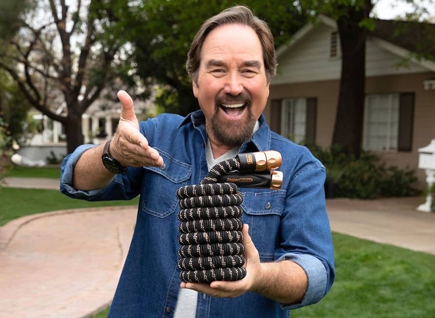 Actor Richard Karn excitedly gesturing toward the pocket hose.