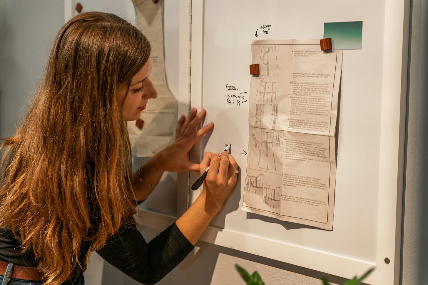 A woman is at a whiteboard, outlining the structure of her newsletter A woman is at a whiteboard, outlining the structure of her newsletter
