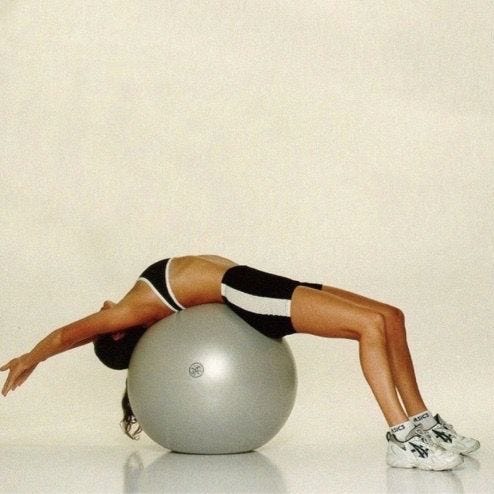 This may contain: a woman is doing exercises on an exercise ball with her arms and legs stretched out