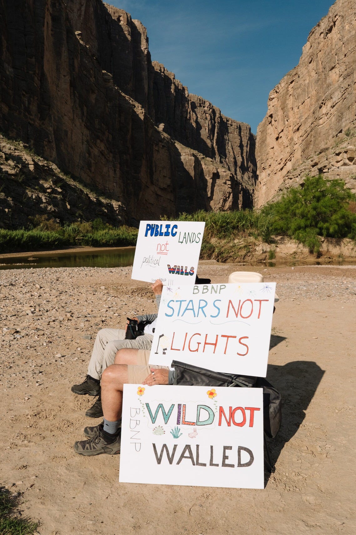 Protesters shield themselves from the sun with their signs on Aug. 12, 2026. (Photo by Sarah M. Vasquez for The Texas Tribune) Protesters shield themselves from the sun with their signs on Aug. 12, 2026. (Photo by Sarah M. Vasquez for The Texas Tribune)