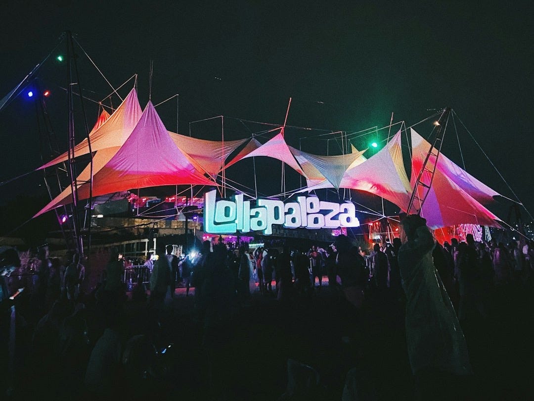 a crowd of people standing around a tent at night