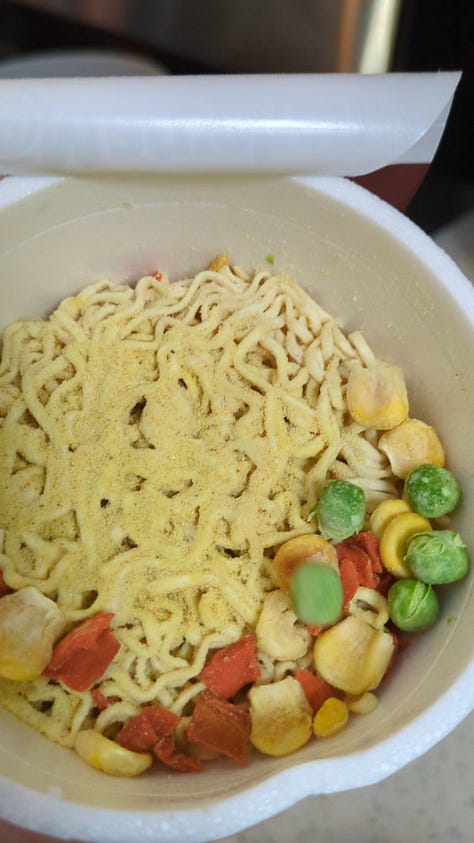 Classic chicken instant ramen cup being opened, cooked, and held up by chopsticks.