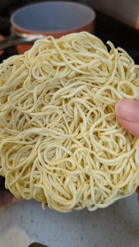 Nissin Raoh instant ramen packet being opened, noodles cooked, sauce packets mixed, and final product served in a delicious soupy bowl.