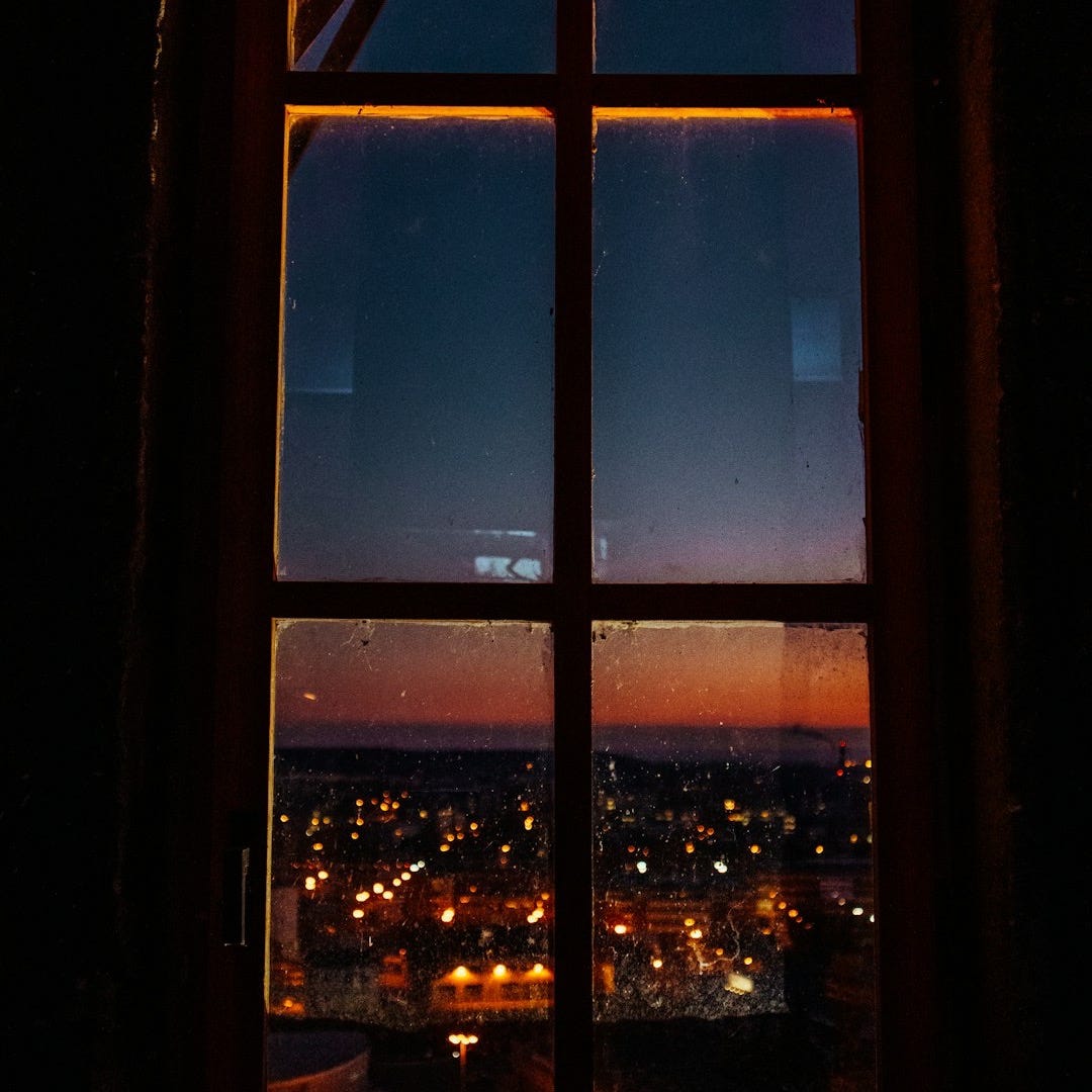 a window with a view of a city at night