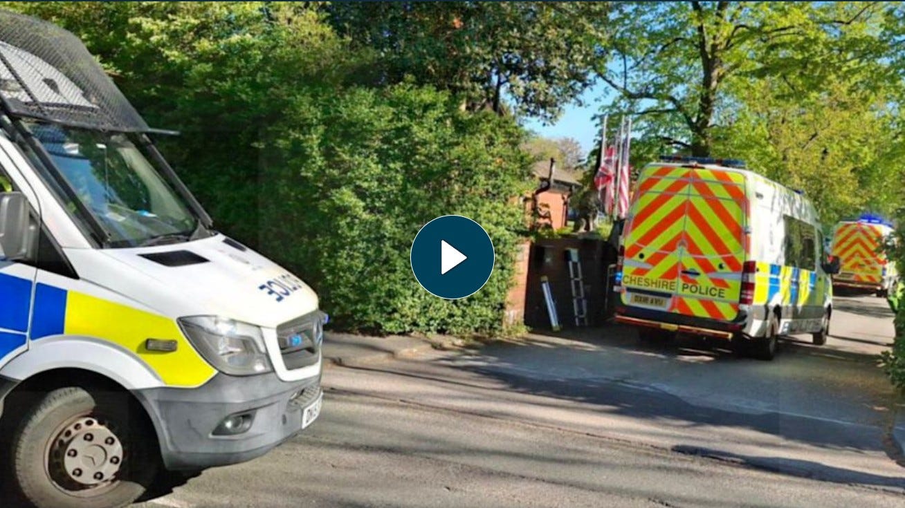  Multiple Cheshire Police vans lined along Victoria Avenue outside Webb House in Crewe during the 29 April 2026 raid on the Ahmadi Religion of Peace and Light compound, with an American flag visible above the entrance hedge