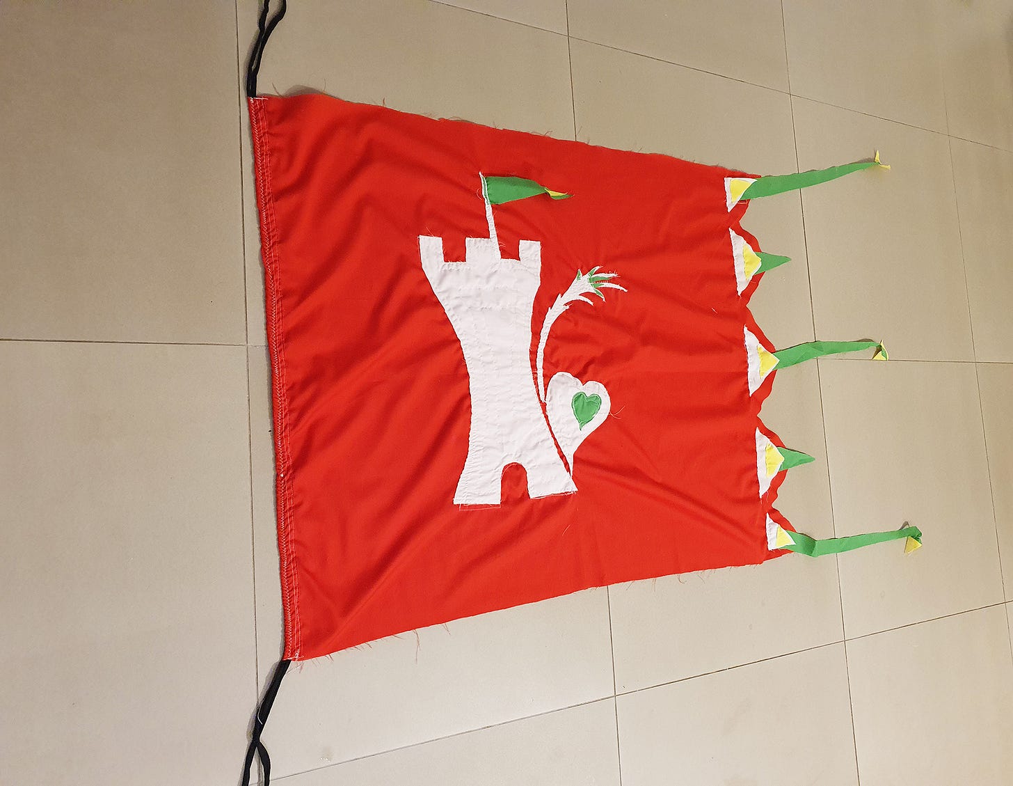 A flag made by McKinleyRd Creatives. A castle mofif with a tree and a flag within a flag.