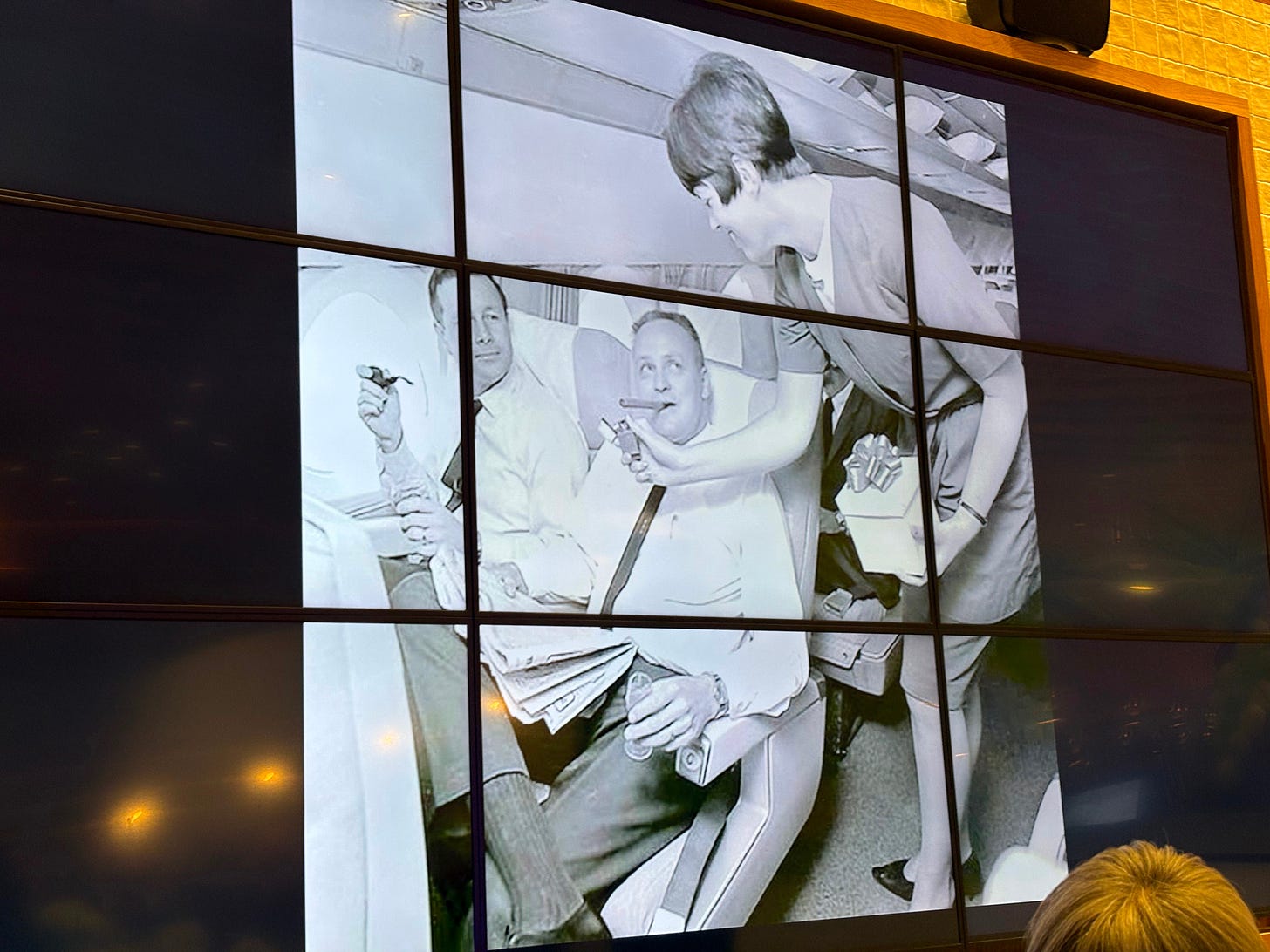 Stewardess lighting male passenger’s cigar. Stewardess lighting male passenger’s cigar.