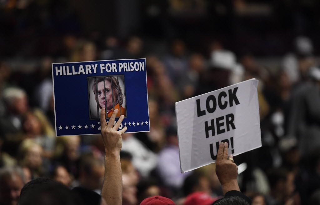 Republican delegates hold signs reading "Hillary For Prison" and "Lock Her Up!" at last...