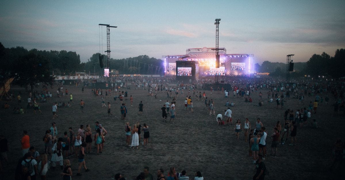 Photo: Bence Szemerey / Pexels Vibrant outdoor concert scene with a lively crowd in Budapest during dusk.