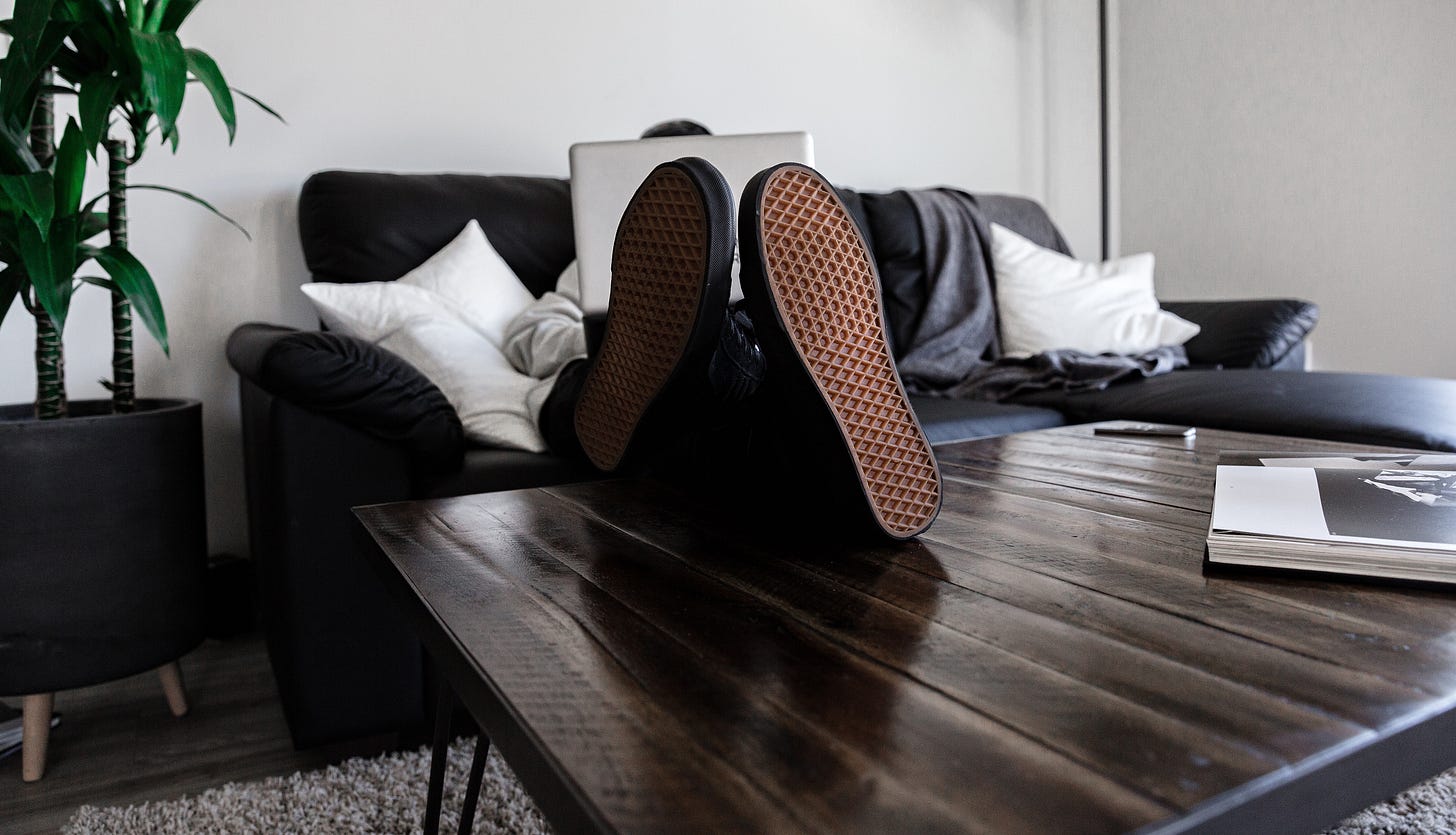 Image of remote worker on sofa with feet on coffee table
