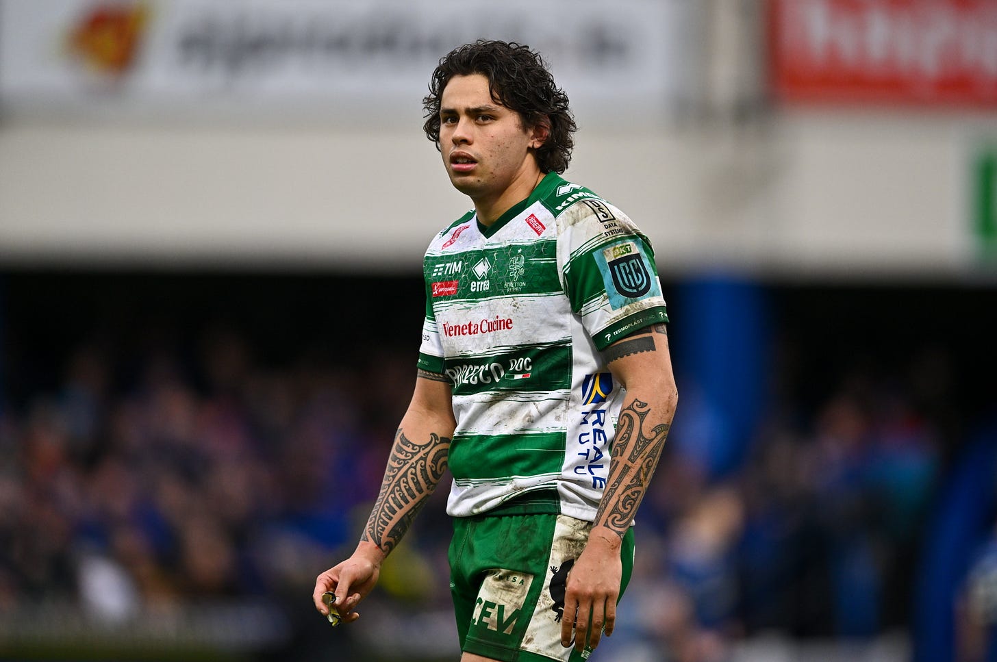 This picture is an image of rugby player Jacob Umaga during a game, wearing a striped green and white Benetton Treviso rugby shirt.