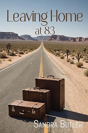 Book cover for Leaving Home at 83. Author: Sandra Butler. It shows three suitcases on the edge of a highway going through the desert toward a mountain range. 