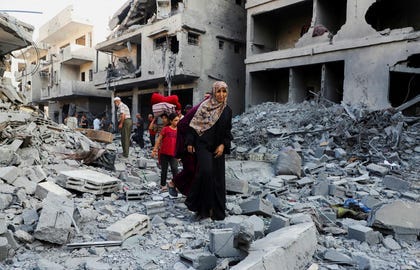 Residents among the ruins of a building bombed in Gaza City, last night. "Vibration. Not a voice at the beginning, but a shiver in the spine. And then the voice," wrote one resident of his experience.