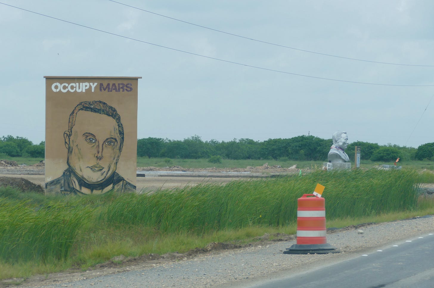 Occupy Mars banner and Elon bust by roadside Occupy Mars banner and Elon bust by roadside