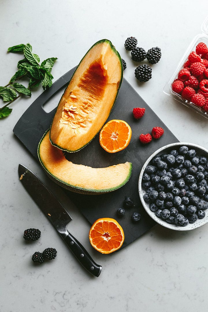 Ingredients for keto fruit salad and a fruit salad on a serving platter.