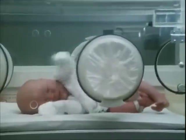 Patrick Bouvier Kennedy; John looks at his ailing son through a screen.