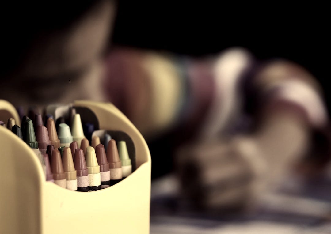 selective focal photo of crayons in yellow box selective focal photo of crayons in yellow box