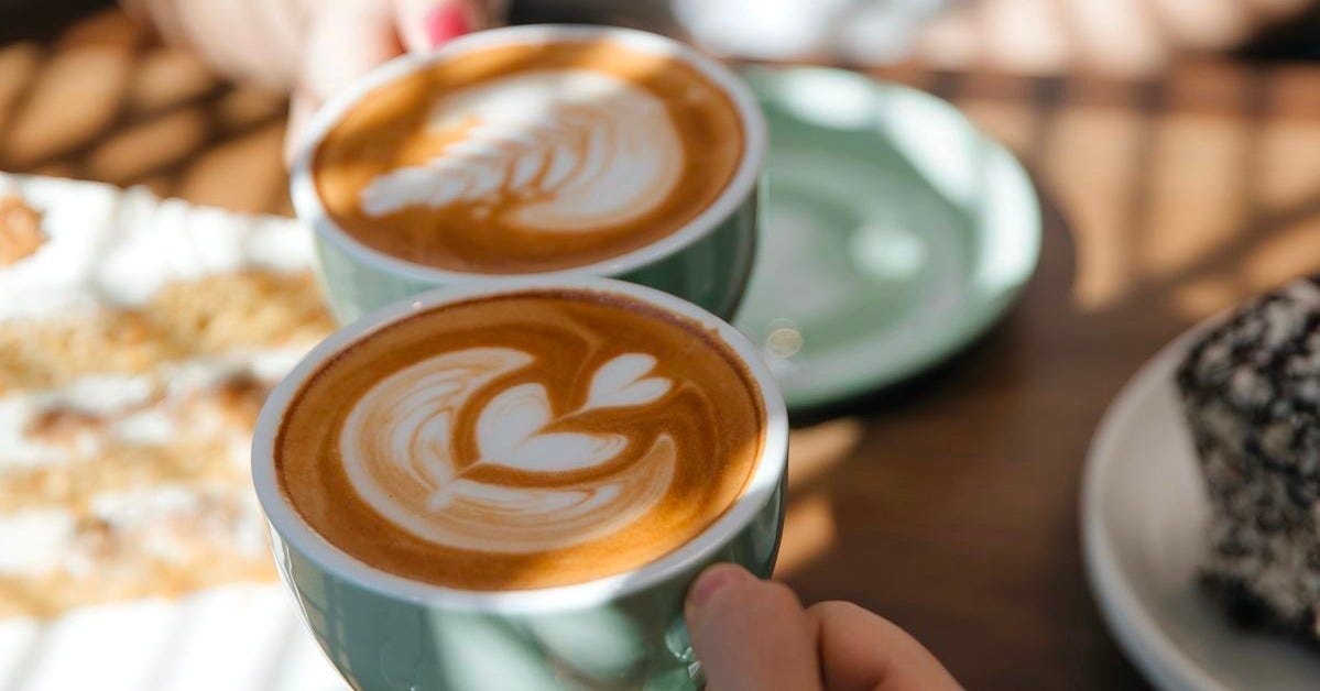 mesa de cafetería íntima con dos tazas y trozo de pastel, ambiente tranquilo mesa de cafetería íntima con dos tazas y trozo de pastel, ambiente tranquilo