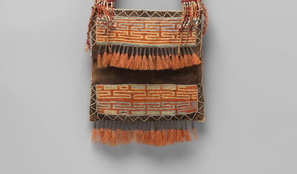 Picture of a shoulder bag created by North American natives from the end of XVIII century. This bag have stripes at its ends and lines that form a zigzag pattern.