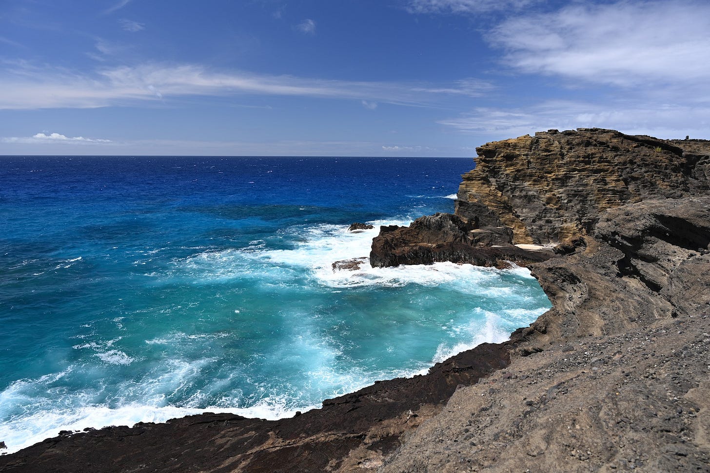 Image of the blue pacific ocean and white foam as it crashes on rocks seen from the Halona Blowhole Lookout in Hawaii Image of the blue pacific ocean and white foam as it crashes on rocks seen from the Halona Blowhole Lookout in Hawaii