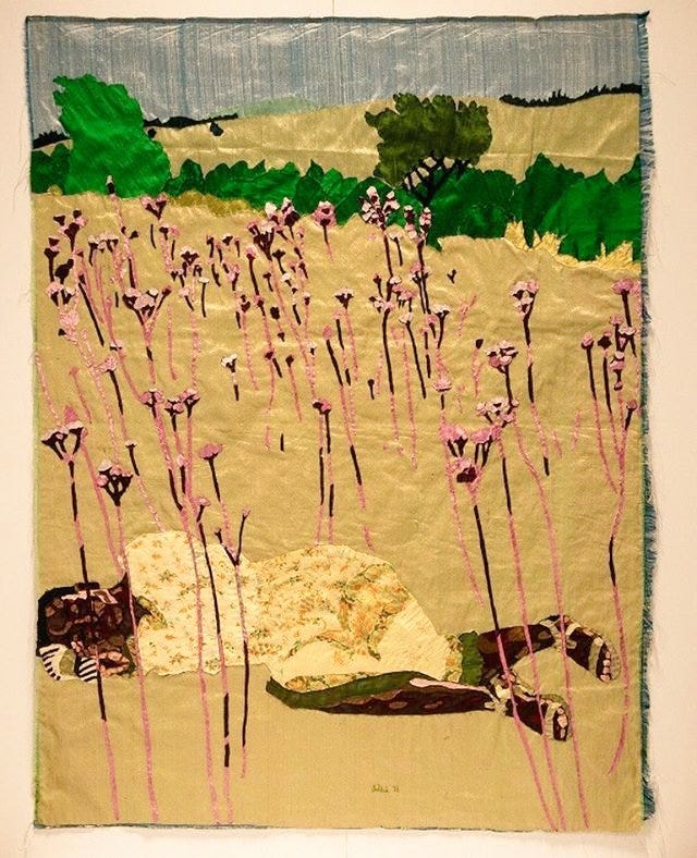 Textile pictorial artwork featuring a Black woman lying in a golden field full of tall pink flowers, she wears a yellow dress and sandals, in the background is a green hedge and another field beyond under a blue sky