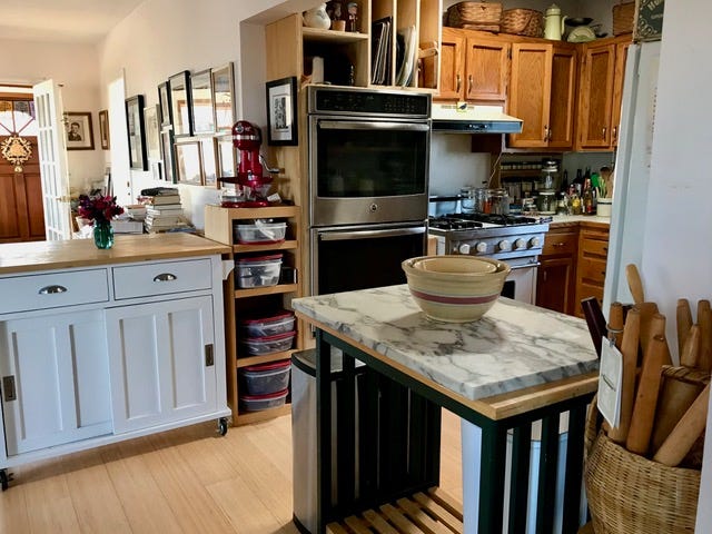 Kitchen with white walls and wooden cupboard doors.