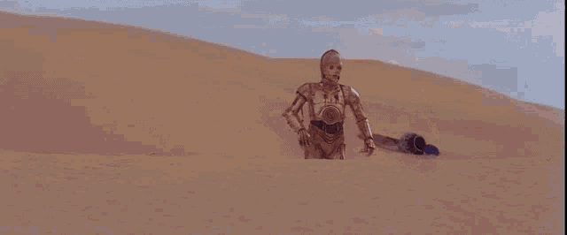 a robot is standing in the desert next to a r2d2 robot