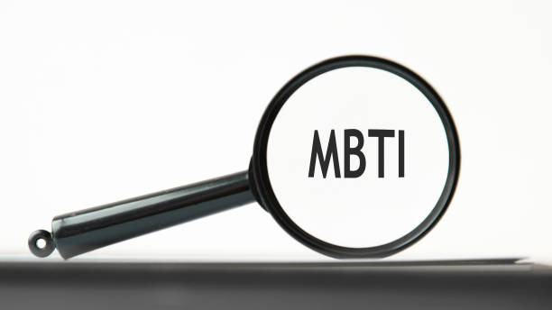 look closely and MBTI with a magnifying glass. business concept. magnifying glass on the gray background looking through a magnifying glass at the word MBTI, a business concept. magnifying glass on the white background. MBTI - short for Myers Briggs Type Indicator myers briggs stock pictures, royalty-free photos & images